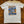 White t-shirt with a graphic design on a wooden surface