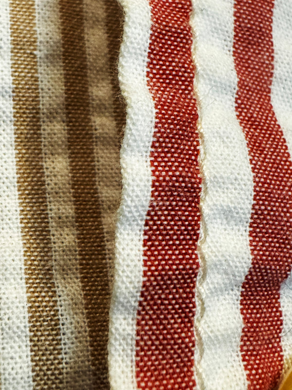 Close-up of a woven textile with vertical stripes in brown, rust red, and off-white.