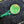 Close-up of a green button with a design on black denim fabric.
